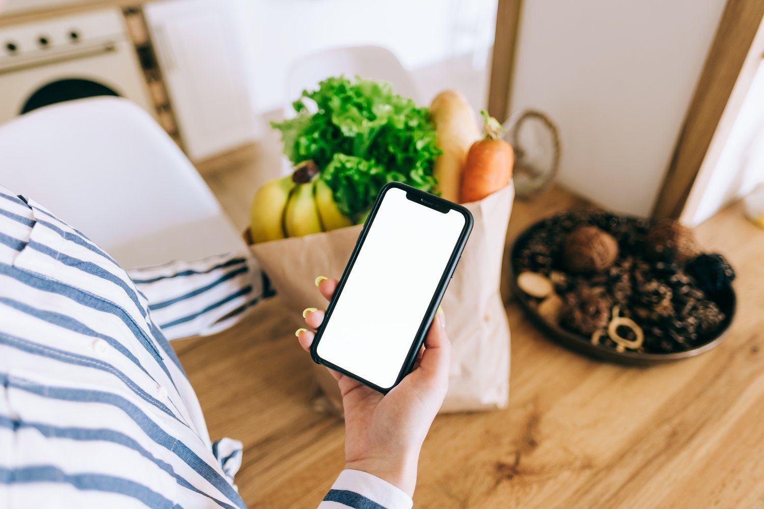 Telefon z otwartym sklepem internetowym na kuchennym stole